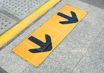 Arrow sign on floor at the sky train