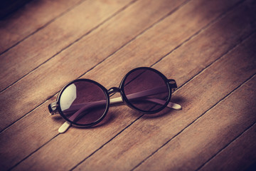 Fototapeta na wymiar Retro sunglasses on wooden table