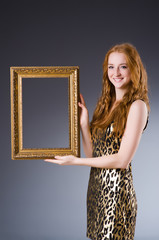 Redhead with picture frame against dark background