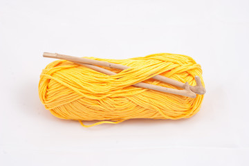 Yellow skein and two ancient crochets on white background