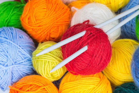 balls of wool yarn and knitting needles