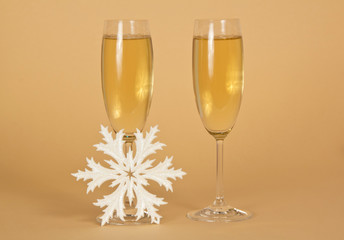 Two wine glasses with champagne and a snowflake