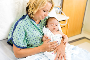 Woman Looking At Babygirl On Hospital Bed