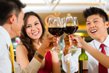 Chinese couples toasting with wine in restaurant