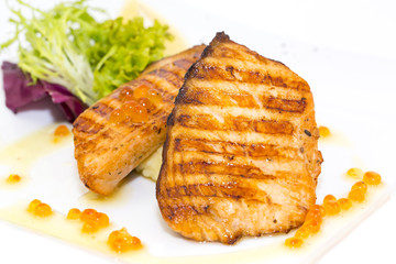 Grilled salmon fillet with vegetables and caviar
