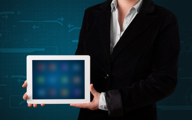 Woman holding a white tablet with blurry apps