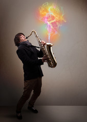 Attractive musician playing on saxophone with colorful abstract