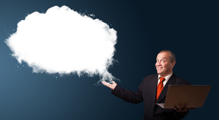 Businessman holding a laptop and presenting abstract cloud copy