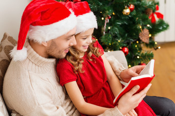 smiling father and daughter reading book