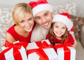 smiling family holding many gift boxes