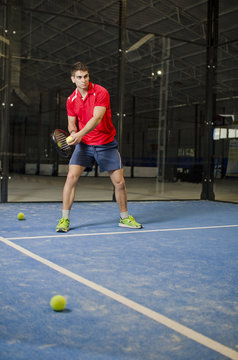 Paddle tennis player in artificial grass court.
