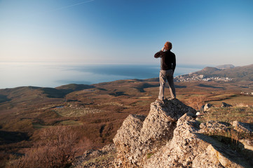 Man with mobile phone on the top of world
