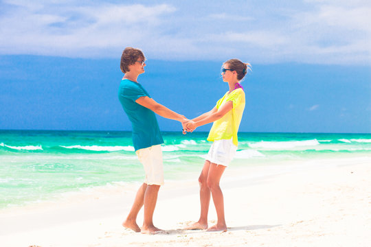 Couple walking and having fun on a tropical beach at Maldives