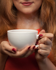 woman holding hot cup and smiles