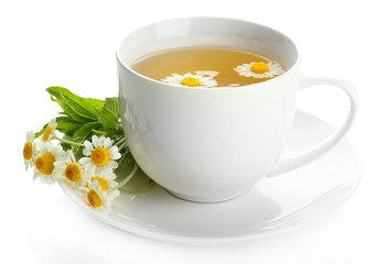 Cup of herbal tea with wild camomiles and mint, isolated