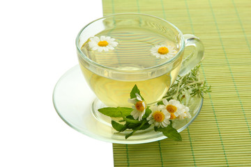 Cup of herbal tea with wild camomiles and mint, isolated