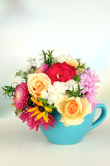 Beautiful bouquet of bright flowers in color mug,