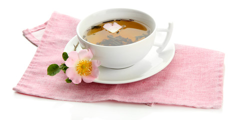 Cup of herbal tea with hip rose flowers, isolated on white