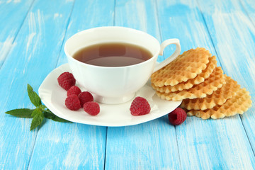 Cup of tea with cookies and raspberries on table close-up
