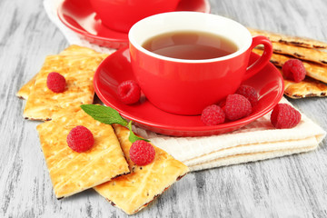 Cups of tea with cookies and raspberries on table close-up