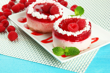Delicious berry cakes on plate on table close-up
