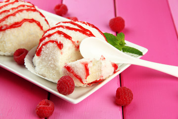 Delicious coconut cakes on plate on table close-up