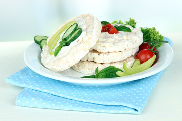 Tasty crispbreads with vegetables on white table