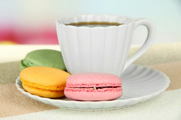 Coffee and macaroons on table on light background