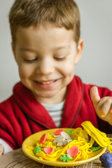 Portrait of child with plasticine spaghetti dish