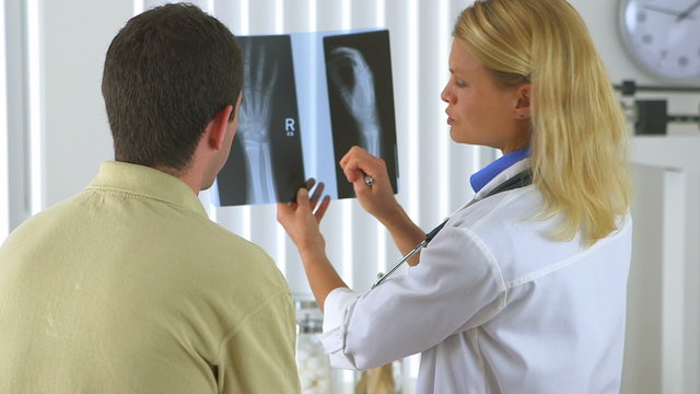 Woman doctor reviewing x-ray with male patient