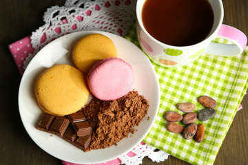 Cocoa in cup with sweets and cocoa powder