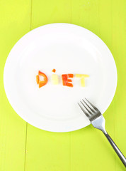 Word diet lined vegetables on plate on wooden table close-up