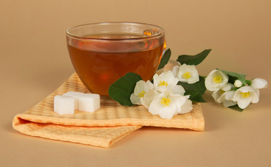 Cup of tea, sugar, branch jasmine and napkin