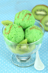 Delicious ice cream on glass vase on blue tablecloth