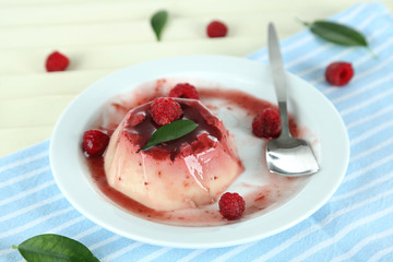 Panna Cotta with raspberry sauce, on wooden background