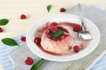 Panna Cotta with raspberry sauce, on wooden background