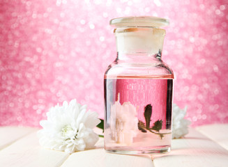 Obraz na płótnie Canvas Butelka szklana z kolorowym istocie, na różowym tle