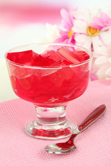 Tasty jelly cubes in bowl on table on light background