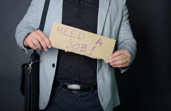 Businessman holding sign "need a job"