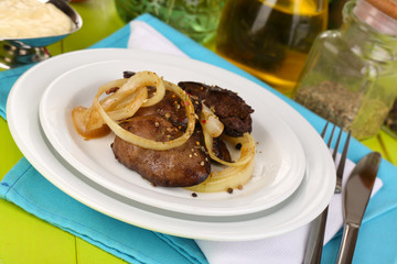 Fried chicken livers on plate on wooden table close-up