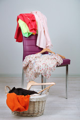 Heap of  clothes on color chair,  on gray background