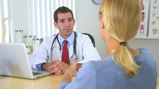 Male doctor speaking with female patient