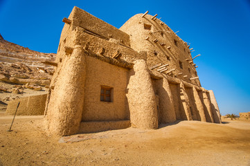 Ancient building made of clay bricks and palm tree