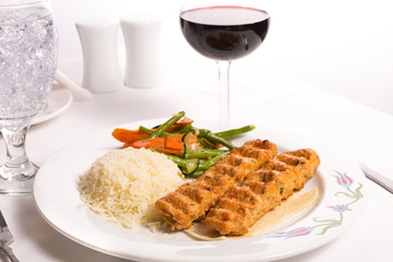 Chicken Adana Kebap Served with Rice Pilaf Vegetables and Red Vi