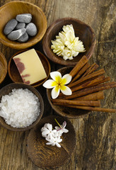 Fototapeta na wymiar salt, cinnamon, frangipani flower in wooden bowl on old wood