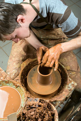 hands of a potter, creating an earthen jar on the circle