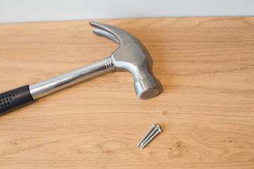 Hammer and nails on wooden surface