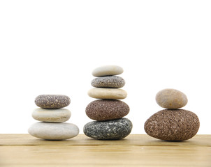 Fototapeta na wymiar Three stacked stones on a wood board
