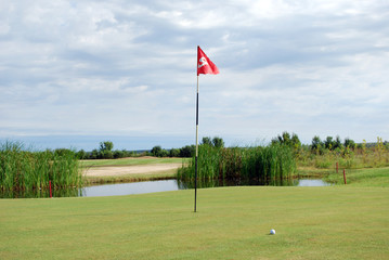 Obraz premium golf course with red flag and ball