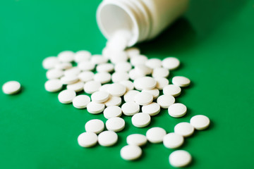 White pills on green background
